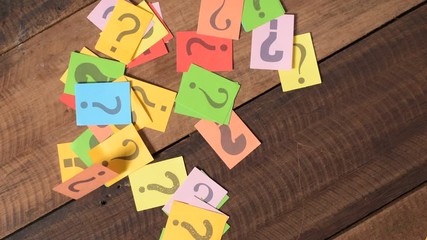 dropping colorful paper note with QUESTION MARK on wooden table. FAQ, questions and problem concept - Powered by Adobe