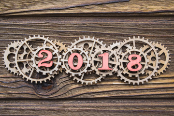 gear wheels and year 2018 on a wooden background. business concept, teamwork, innovation project, cooperation, strategy. management of business processes and automation of the hiring process