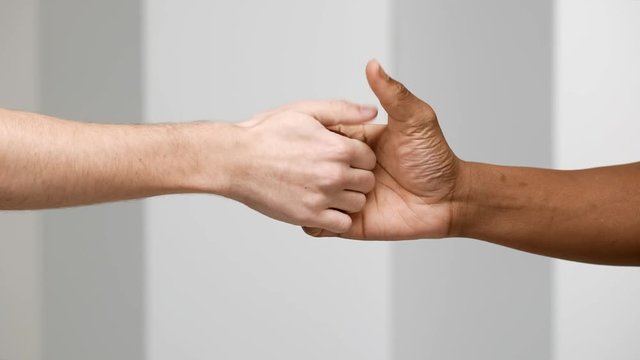 Two male hands playing thumb wars closeup, isolated over white background in slow motion, arm gestures concept