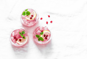 Obraz na płótnie Canvas Pomegranate tequila cocktail. Summer light alcoholic drink, cooling aperitif. On light background, top view, free space. Flat lay