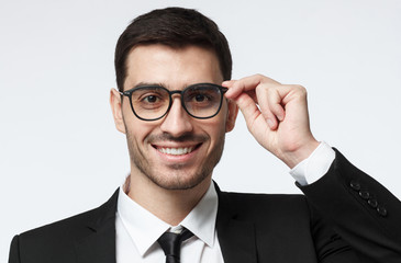 Successful professional, head banking, property, sales, insurance manager, holding his fashionable spectacles with one hand, looking at camera