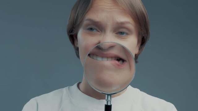 portrait of caucasian wooman with magnifier make ull faces