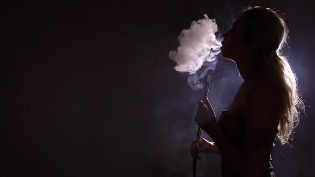 Young woman smoking hookah silhouette