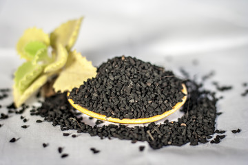 Close up of oil of kalonji with ayurvedic herb ajwain isolated on white used to remove cough and for weight loss.