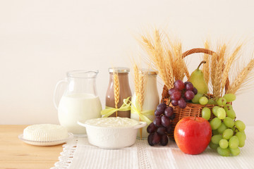 image of dairy products and fruits over wooden table. Symbols of jewish holiday - Shavuot.