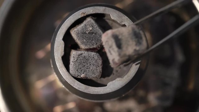 Man preparing hookah bowl and coald for smoking shisha