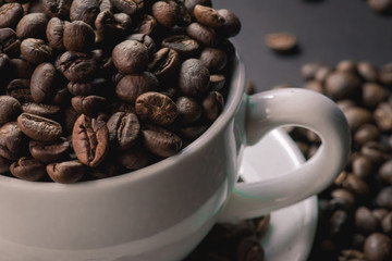 coffee in white cup and coffee beans are the background.