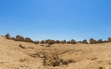The stones are laid out in a semicircle in a desert area, next to the place of tectonic fault of the slabs