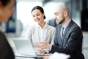 One of managers explaining his colleague online information while analyzing statistics of stock market sales