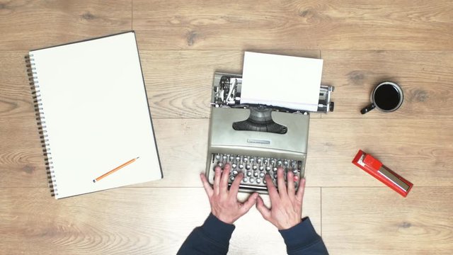 Book writing by the window with a vintage typewriter. 4K video colors and black and white