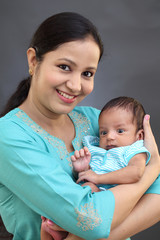 Cheerful mother holding newborn baby