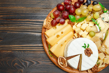 various types of cheese on wooden cutting board