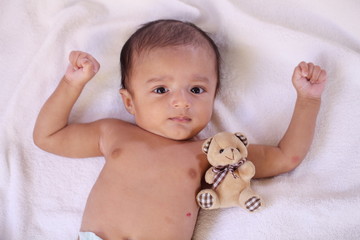 Newborn baby boy with teddy bear on bed - 200669702