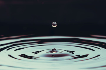 QUEBEC, QC - Canada December 2012 : Aftermath of a drop over ripples of water. The action is centered and shows strength but calmness.