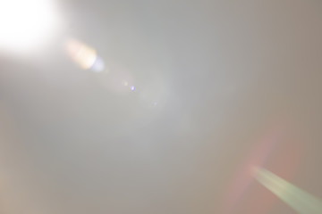 Solar camera lens flare light create ring of objective iris shapes of different rainbow colors depending on used antireflection coating of each lens surface on white background