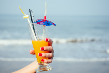 refreshing cocktail on the background of the sea in the hands of a beautiful girl