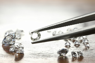 brilliant cut diamond held by tweezers