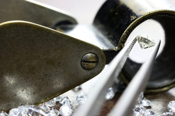 brilliant cut diamond held by tweezers