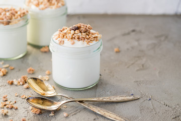 Yoghurt with granola made of oats, raisins, puffed rice, chocolate and dried bananas. Healthy breakfast for family.