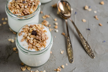 Yoghurt with granola made of oats, raisins, puffed rice, chocolate and dried bananas. Healthy breakfast for family.