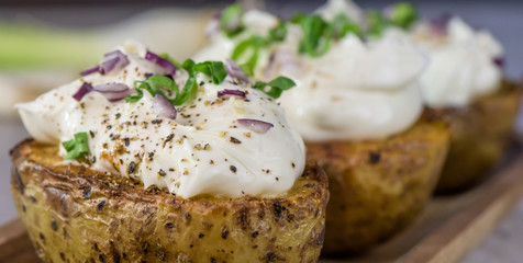 Baked potatoes with curd white cheese, red onion and chive - closeup - banner 