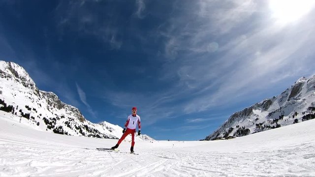 front view of one male cross country skier in race suit with start number 1 on cross country trail on sunny winter day in slow motion
