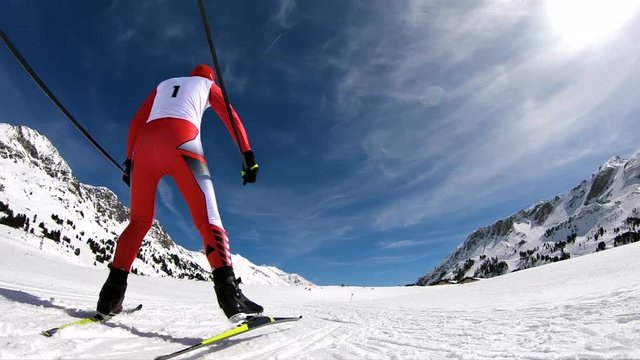 slow motion one cross country skier in race suit with start number 1 rear view skating on sunny winter day
