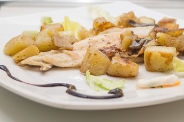 sea bass in the dish with potatoes and salad