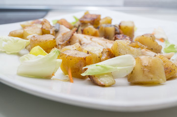sea bass in the dish with potatoes and salad