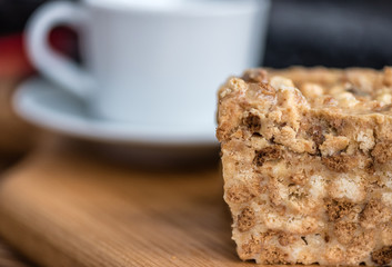 An anthill cake in the background of a cup of coffee