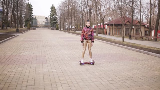 Sad girl rides an electronic scooter in an empty Park