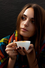 a young beautiful girl with hips on her shoulders holding a cup of coffee thoughtfully looking sideways, a cute portrait