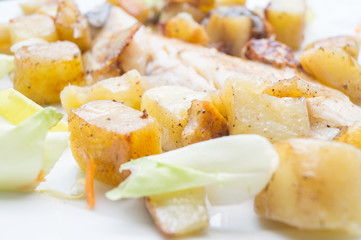 sea bass in the dish with potatoes and salad