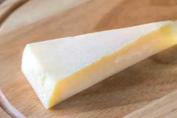 Grana Padano cheese on the wooden board