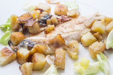 sea bass in the dish with potatoes and salad