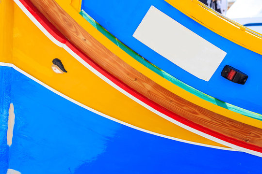 Traditional colorful boat luzzu at the port of Marsaxlokk, Malta. Copy space, closeup view