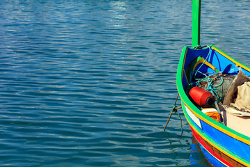 Traditional colorful boat luzzu at the port of Marsaxlokk, Malta. Copy space, closeup view
