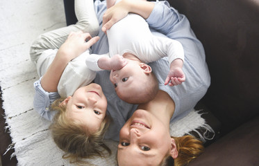 Young mother hugging two little children