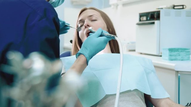 Dentist checking teeth of girl