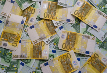 Scattered 200 euro, 100 euro, banknotes - background.
