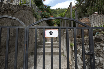 The sign on the fence with the dog's image