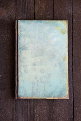 closed old blue note book on dark wooden background