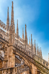 Fototapeta na wymiar Spiers and statues on the gothic Cathedral of Milan, Italy