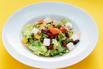 greek salad on yellow background