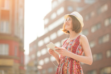 Girl using a tablet computer outdoor on a city street