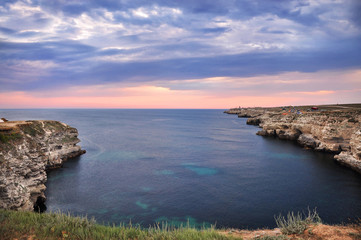 Fototapeta na wymiar High cliffs of the sea shore. The evening landscape by the sea.