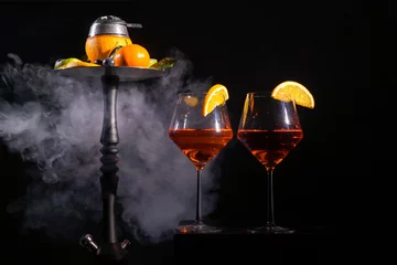 Outdoor-Kissen Pair of glasses with alcoholic drink beverage wine cocktail and hookah with fruits black background isolated © lookproduction