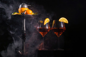 Pair of glasses with alcoholic drink beverage wine cocktail and hookah with fruits black background isolated