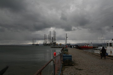 Crab pots in Cromarty Harbour overlooking oil rigs in the firth, Black Isle, Scotland