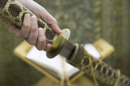 Sword and Quran on the lectern. The biggest gun is a book.Ramadan concept.
